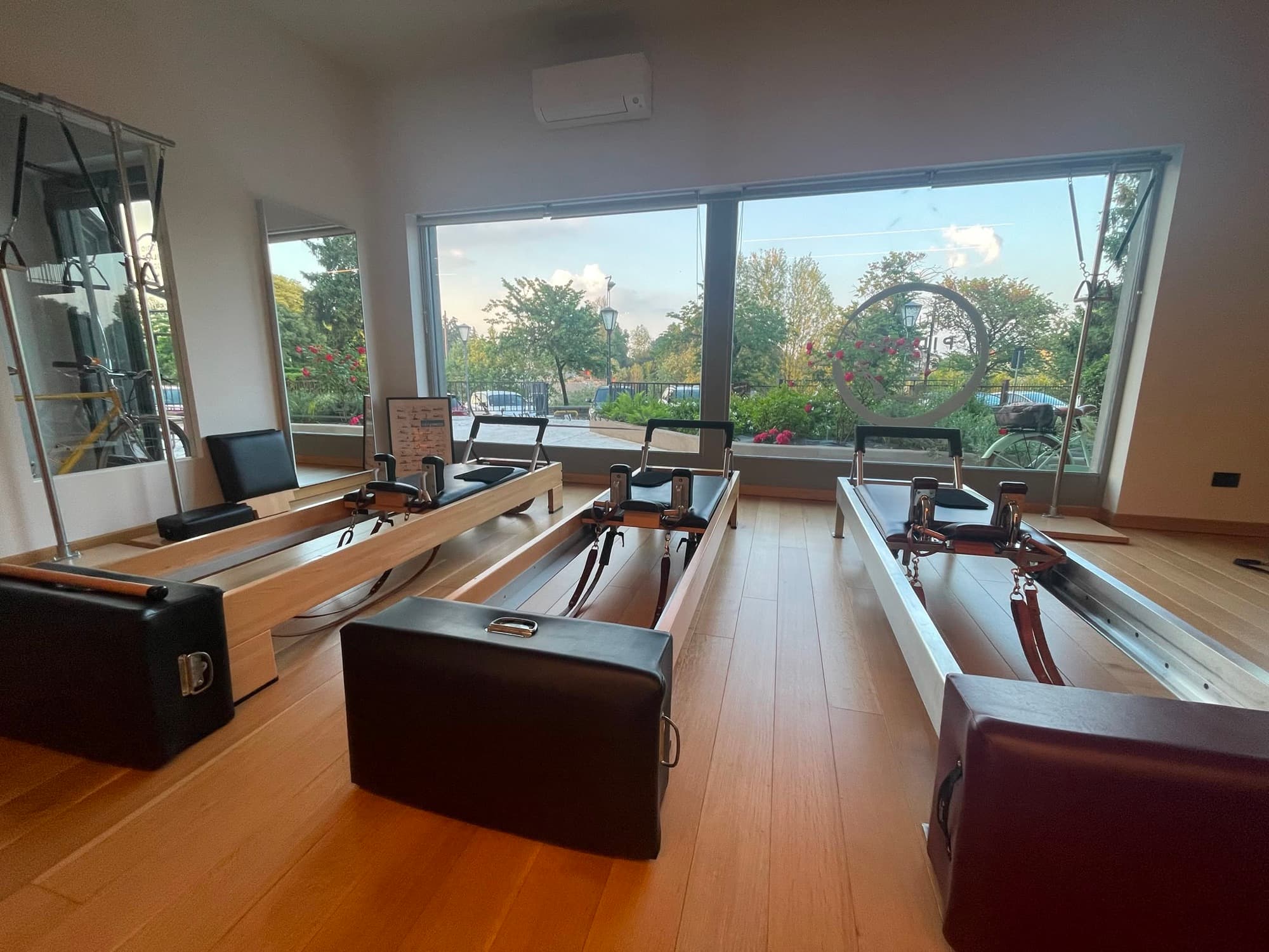 La sala Reformer dello Studio Pilates Lodi, con le vetrate sul verde